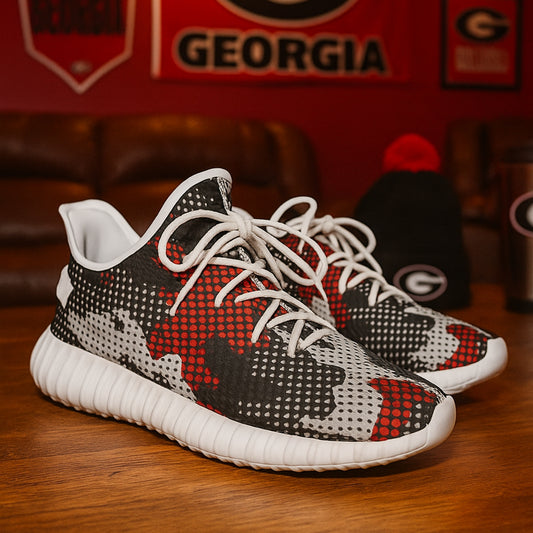 Black, red, and white sneakers on a wooden floor with a blurred background featuring 'Georgia' branding.