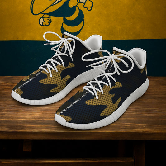 Black and gold sneakers with white laces on a wooden surface, against a yellow and blue background.