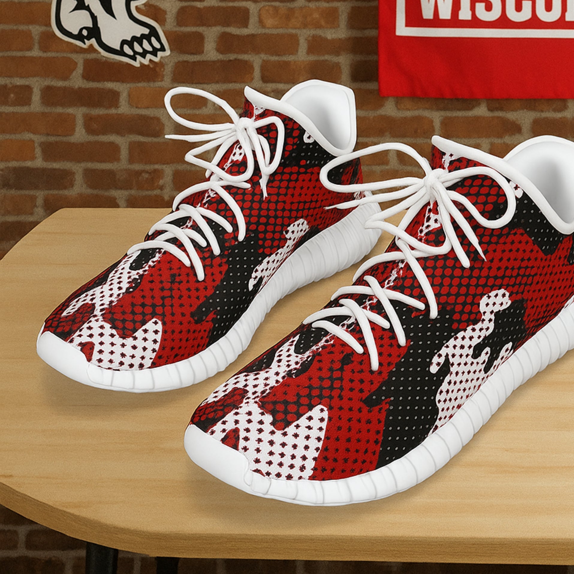 Red, black, and white patterned sneakers on a wooden table with a brick wall background.